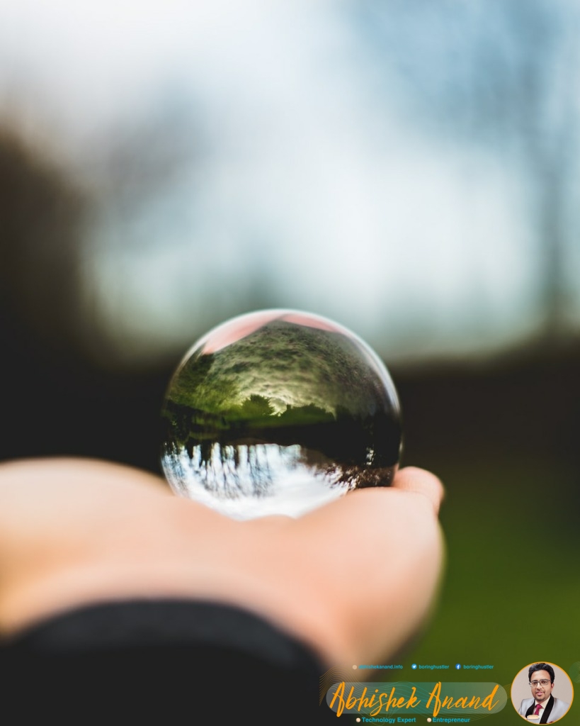 person holding round glass ball