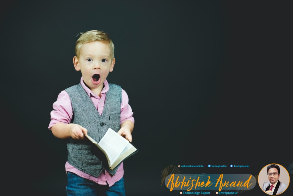 boy wearing gray vest and pink dress shirt holding book